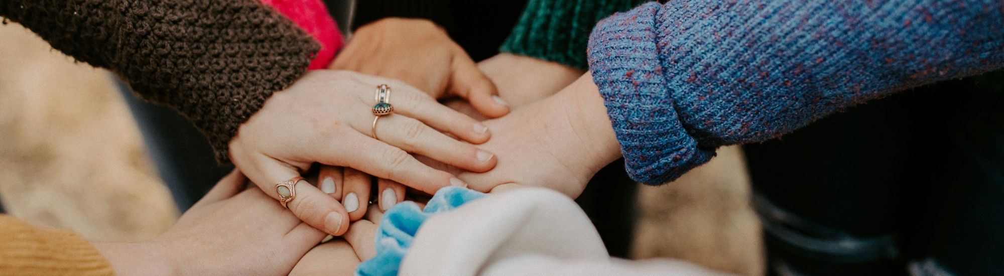 the center of a circle of hands one on top of the other.